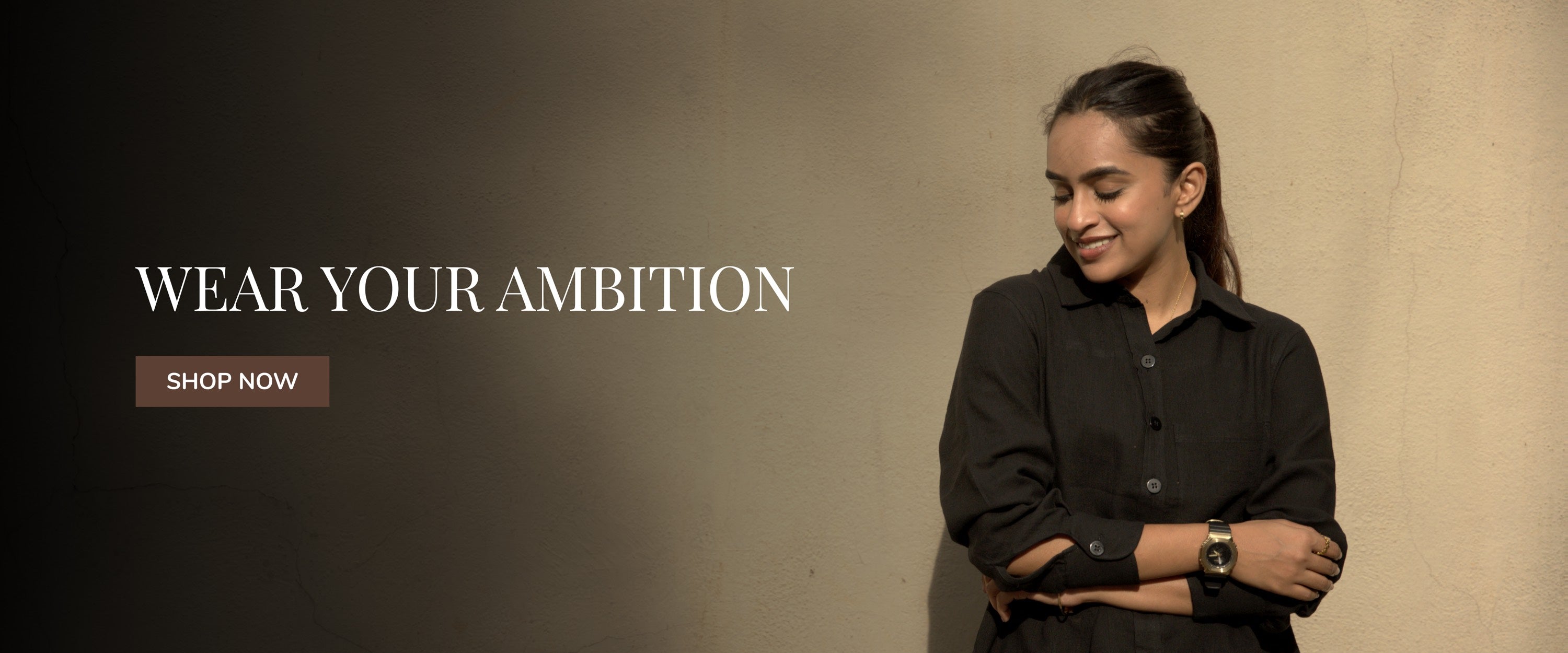 Woman in smart casual work wear boardroom basic black shirt with 'Wear Your Ambition' text and 'Shop Now' button on a gradient background